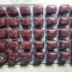 A tray of chocolate covered marshmallows sitting on top of a table.